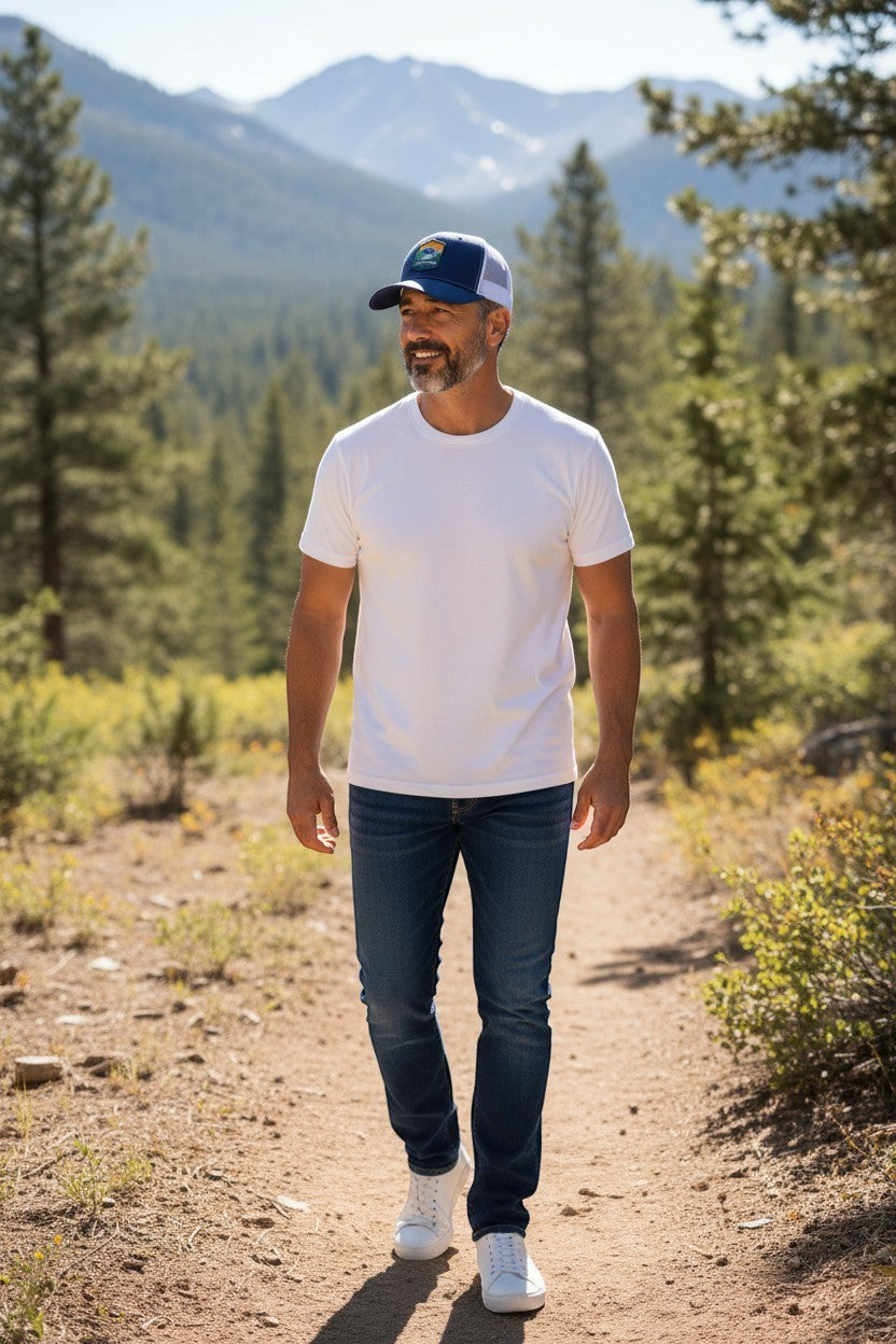 Moove Headwear navy blue trucker hat with Rocky Mountain National Park patch and white mesh back. Man wearing hat outdoors.