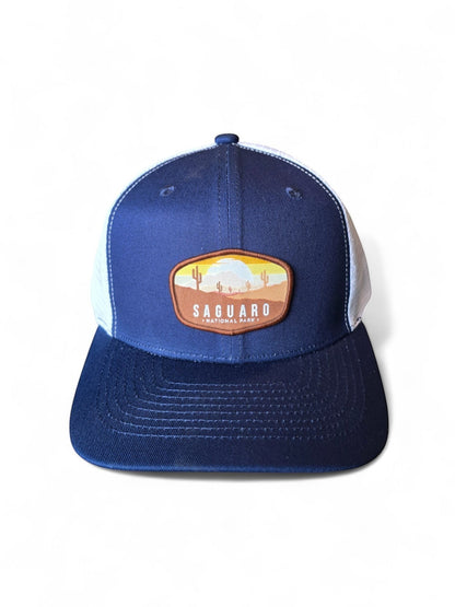 Moove Headwear navy blue and white mesh trucker hat with Saguaro National Park embroidered patch.