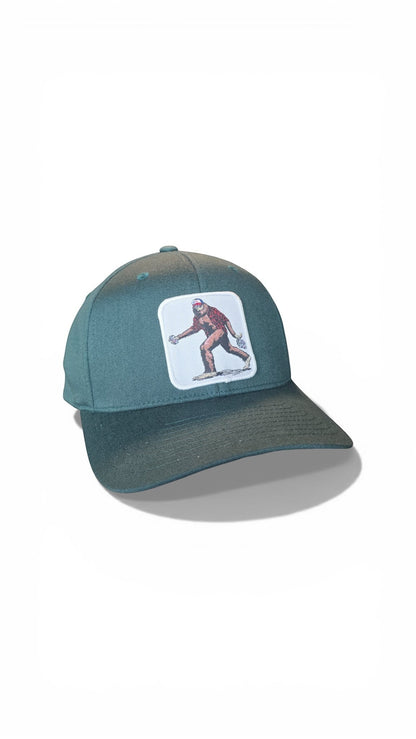 Moove Headwear teal baseball cap with embroidered Sasquatch graphic. Fitted dad hat style.