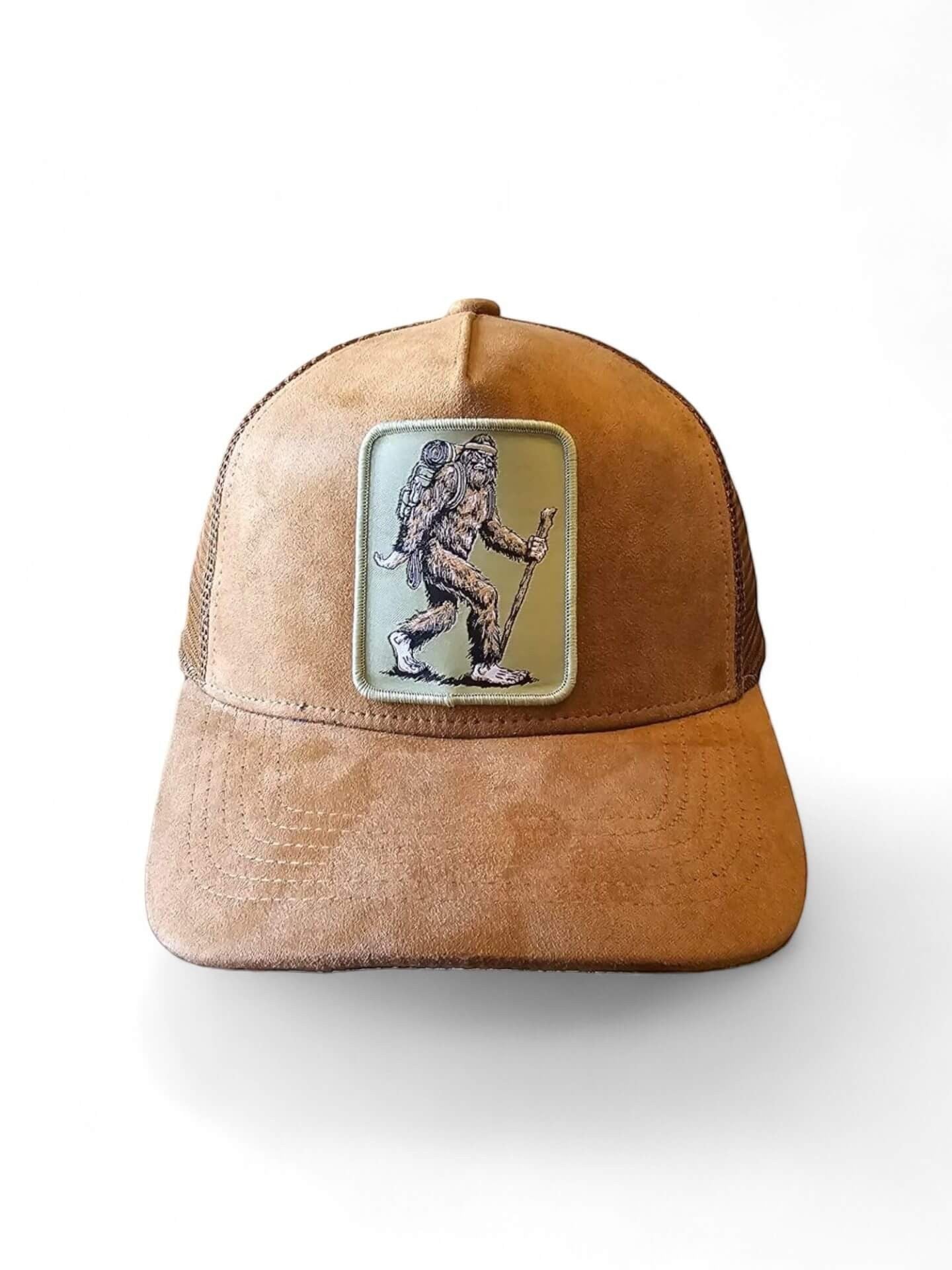 Moove Headwear brown suede trucker hat with Sasquatch hiker patch and mesh back. Adjustable snapback.