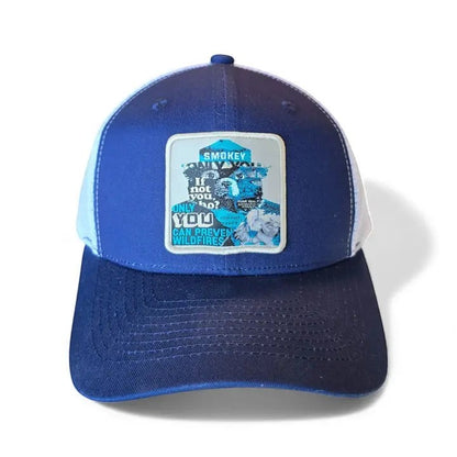 Moove Headwear Smokey Bear trucker hat with blue front panels and white mesh back. Features a patch with Smokey Bear and "If not you, only you? YOU CAN PREVENT WILDFIRES."