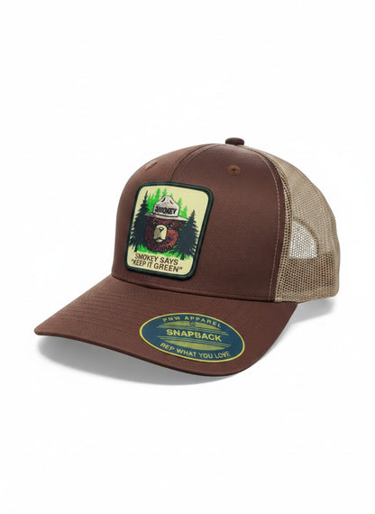 Moove Headwear brown trucker hat with mesh back, featuring a Smokey Bear logo patch and adjustable snapback closure.