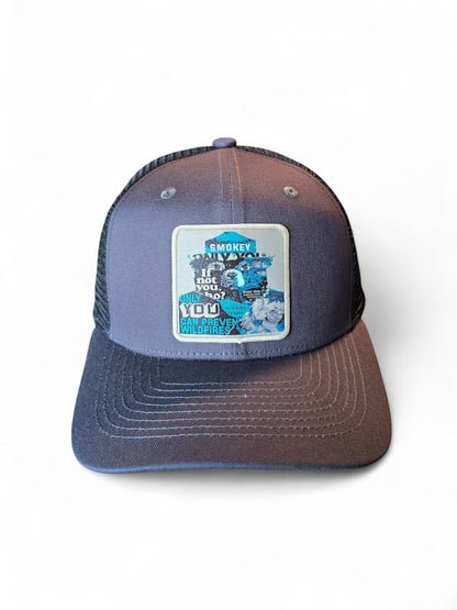 Moove Headwear Smokey Bear trucker hat with mesh back, grey front panel, and a patch that says "Smokey, Only You Can Prevent Wildfires."