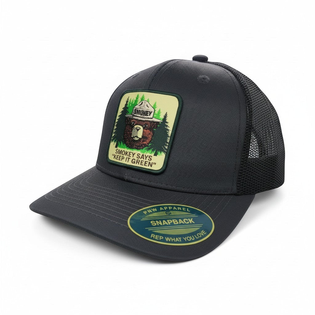 Moove Headwear dark grey mesh back trucker cap with Smokey Bear logo patch promoting fire safety.