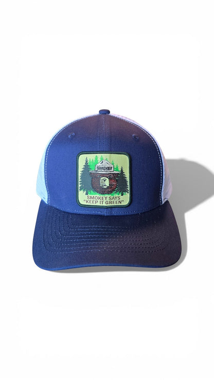 Moove Headwear navy blue trucker cap with white mesh back and Smokey Bear patch. Adjustable snapback.