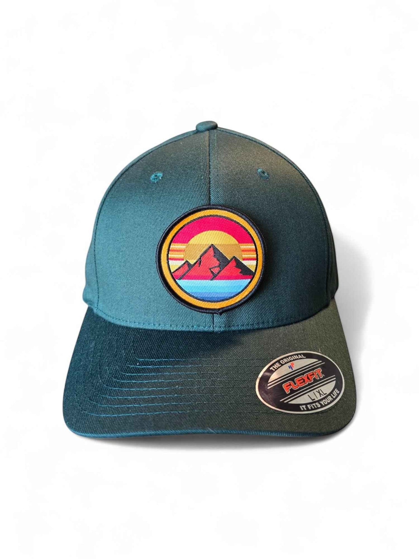 Moove Headwear dark teal Flexfit hat with retro sunset mountain patch. Features embroidered design with mountains, sun, and rainbow stripes.