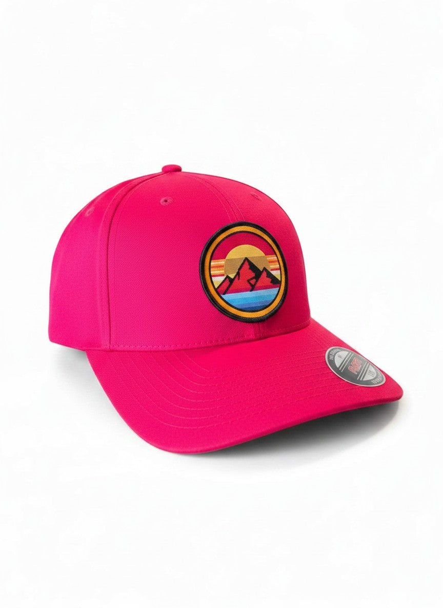 Moove Headwear bright pink fitted hat with retro embroidered sunset mountain patch. Features Flexfit technology.