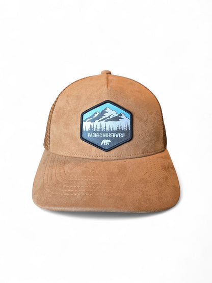 Moove Headwear tan suede trucker hat with mesh back and Pacific Northwest mountain patch. Adjustable snapback.