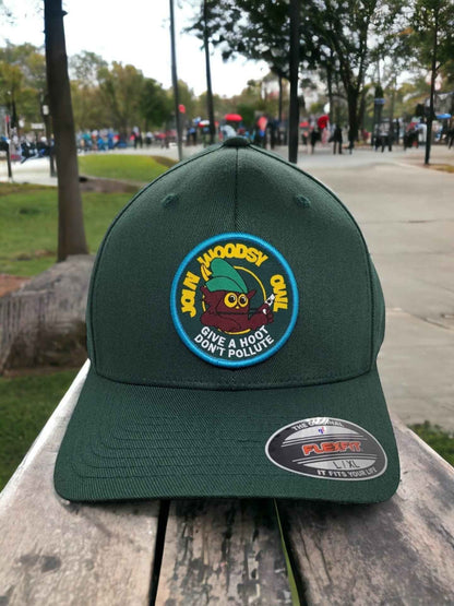 Moove Headwear dark green baseball cap with a woven patch of Woodsy Owl saying "Give a Hoot Don't Pollute".