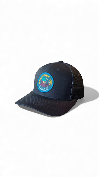 Moove Headwear black trucker hat with a circular Woodsy Owl patch promoting conservation. Features mesh back and adjustable snapback.